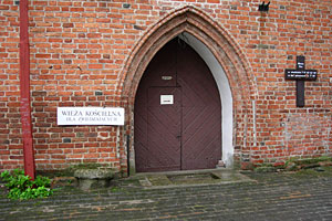 Foto. 3. Boczne wejście kościoła z widocznym po lewej stronie pręgierzem fot.Tadeusz Rawa