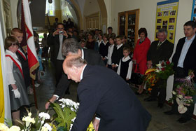 Burmistrz Reszla i przewodniczący rady miejskiej składają kwiaty pod tablicą
 fot.Sylwia Ciesiun