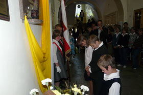 Uczniowie składają wiązankę kwiatów pod tablicą
 fot.Sylwia Ciesiun