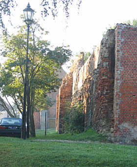 fragment zachodniej części murów miejskich z basztą w tle