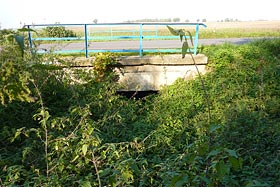 Kamienno-betonowy most drogowy na nieczynnym kanale wodociągowym przecinającym drogę do Świętej Lipki. Foto.